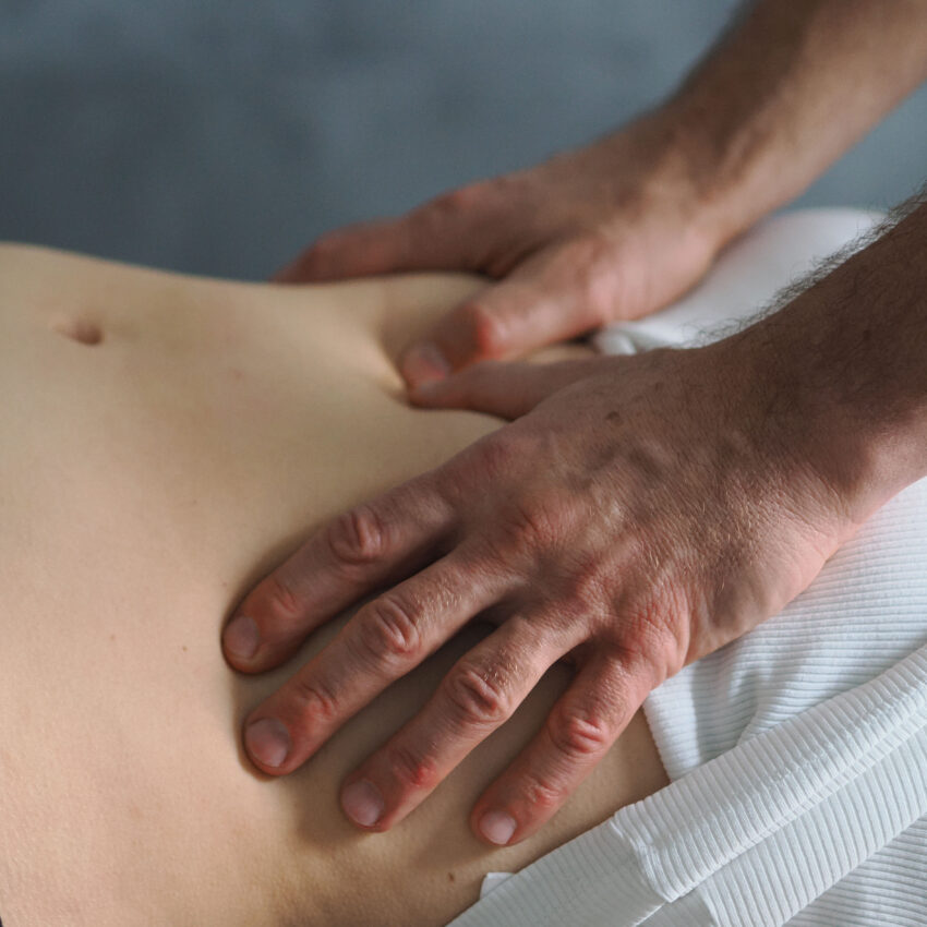 Osteopata wykonujący terapię wisceralną na pacjencie w przychodni Biomed na Bielanach w Warszawie