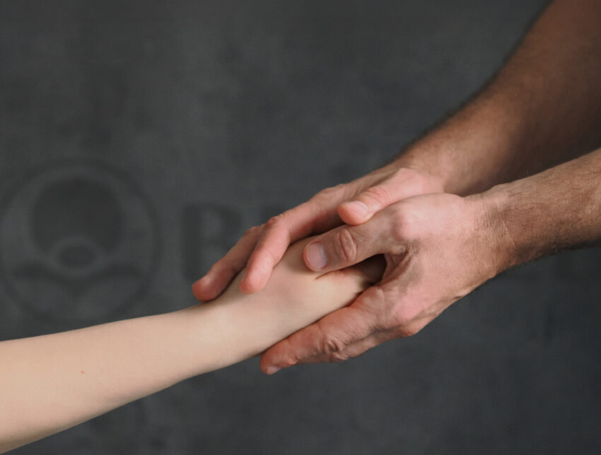 Terapeuta trzymający rękę pacjenta w przychodni Biomed