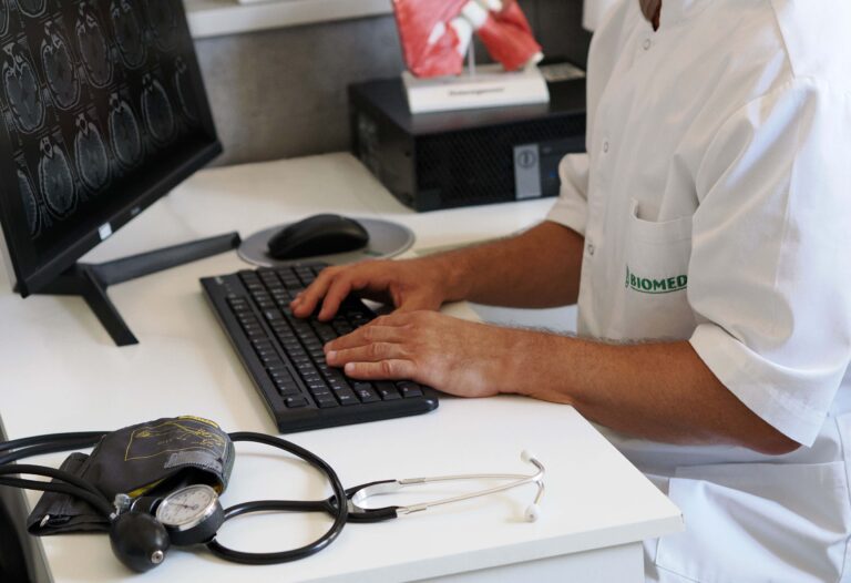 Lekarz oglądający na laptopie wyniki fMRI kręgosłupa w przychodni Biomed